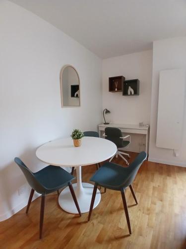 - une table et des chaises blanches dans la chambre dans l'établissement très bel appartement 2 pièces, à Brétigny-sur-Orge
