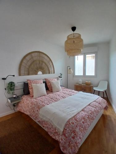 une chambre avec un grand lit avec une couverture rose dans l'établissement très bel appartement 2 pièces, à Brétigny-sur-Orge