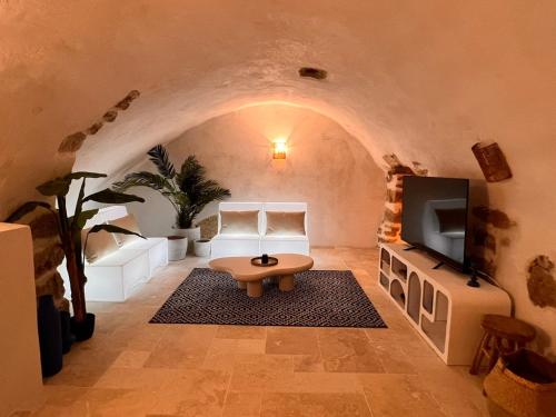 un salon avec un canapé et une télévision dans l'établissement Les Caves d 'Oía, à Aix-en-Provence