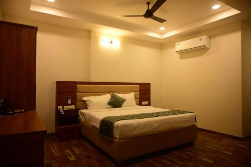 a bedroom with a bed and a ceiling fan at Manthra Hotel, Basavakalyan in Basavakalyān