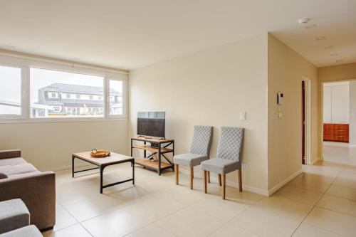 a living room with a couch and chairs and a tv at Gray Fox Apartments - San Martin in Ushuaia
