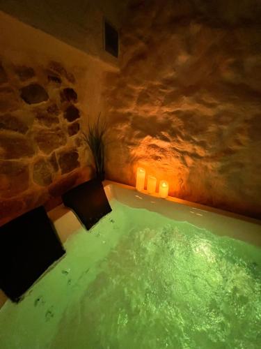 une grande baignoire verte dans une chambre avec un mur en pierre dans l'établissement Les Caves d 'Oía, à Aix-en-Provence