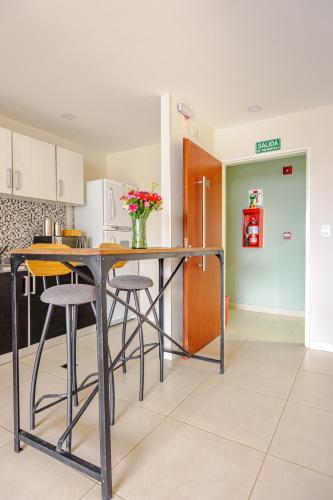 a kitchen with a table and stools in a room at Gray Fox Apartments - San Martin in Ushuaia