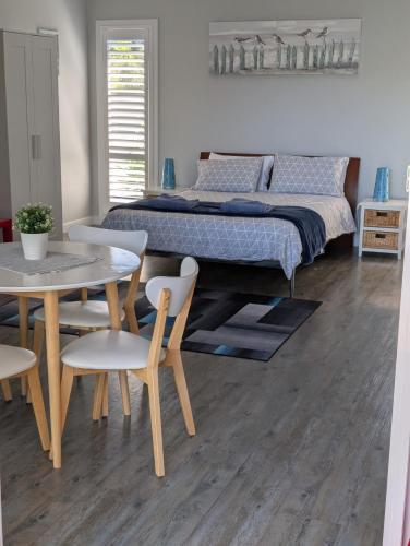 a bedroom with a bed and a table and chairs at Southern Comfortable in Goolwa North
