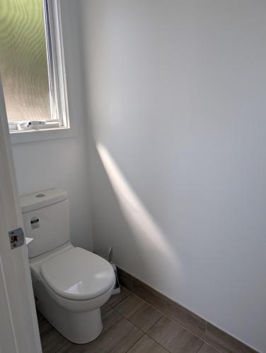 a bathroom with a white toilet and a window at Southern Comfortable in Goolwa North