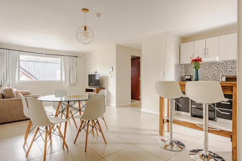 a kitchen and living room with a table and chairs at Gray Fox Apartments - San Martin in Ushuaia