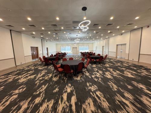 a large room with tables and chairs in it at Clarion Inn & Suites Dothan South in Dothan