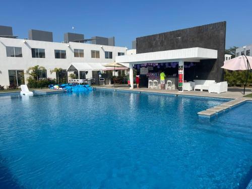 a large pool of blue water in front of a building at Casa Monstera Bahia in Naranjo