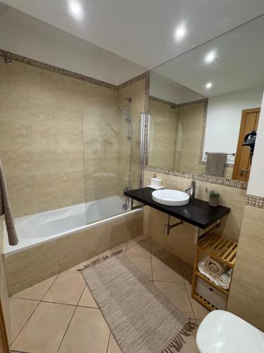 een badkamer met een bad, een wastafel en een toilet bij Apartamento Altumar T2 in Portimão