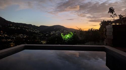 a view of the sunset from a swimming pool at Tropical Haven 2 pieces contemporain avec piscine in Les Trois-Îlets