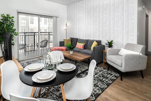 a living room with a couch and a table and chairs at Urban Retreat - Free Parking, WiFi, Walk to Stadium in Charlotte
