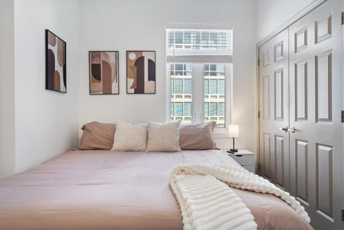 a white bedroom with a bed with a white door at Queen City Retreat - Parking, Views, Near Stadium in Charlotte