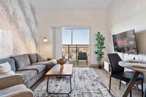 a living room with a couch and a table at Cozy City Charm - Spacious, Parking, Balcony, Gym in Charlotte