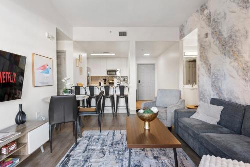 a living room with a couch and a table at Cozy City Charm - Spacious, Parking, Balcony, Gym in Charlotte