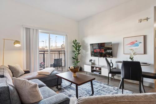 a living room with a couch and a table at Cozy City Charm - Spacious, Parking, Balcony, Gym in Charlotte