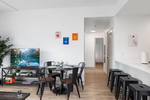 a dining room with a table and black chairs at The Tar Heel - Stylish 4BR with City Views - Free Parking - Gym in Charlotte