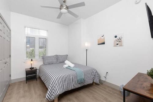 a bedroom with a bed and a ceiling fan at The Tar Heel - Stylish 4BR with City Views - Free Parking - Gym in Charlotte