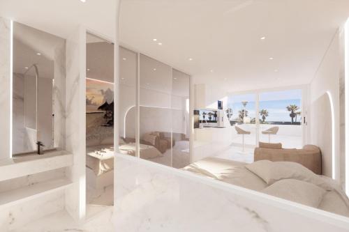 - un salon avec des murs blancs et un grand miroir dans l'établissement Naturiste Cap d'Agde Héliopolis AB 30, au Cap d'Agde