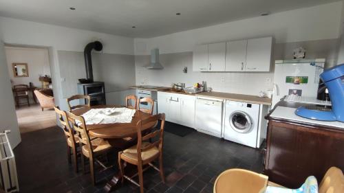 a kitchen with a table and a kitchen with a washing machine at Le relais de Noron in Noron-la-Poterie