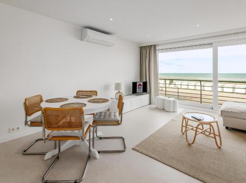 a white living room with a table and chairs at Stormvogel 0102 P15 in Sint-Idesbald