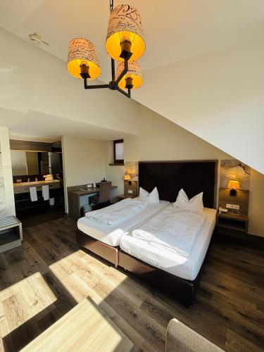 a bedroom with a large white bed with two lights at Posthotel Walhalla Regensburg Ost in Donaustauf