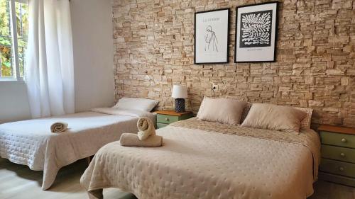 a bedroom with two beds and a brick wall at Bakit House - Casa rural con piscina in Águilas