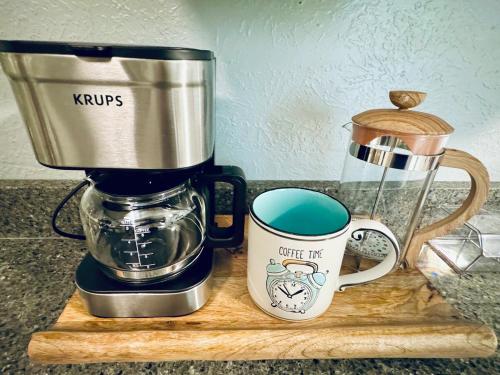 a coffee maker and a coffee mug on a cutting board at Relax & Unwind in 2BR 1BA Home in Quiet Neighborhood in Nederland