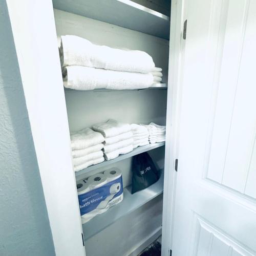 a closet with white towels and a box in it at Relax & Unwind in 2BR 1BA Home in Quiet Neighborhood in Nederland