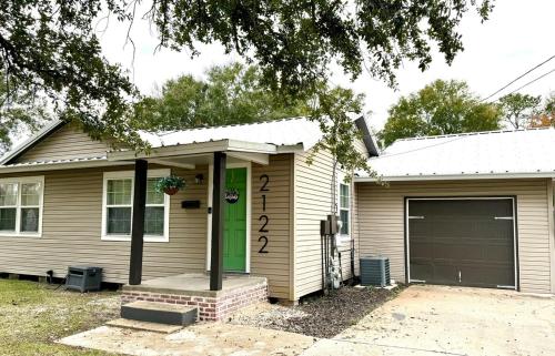 a house with a green door and a garage at Relax & Unwind in 2BR 1BA Home in Quiet Neighborhood in Nederland