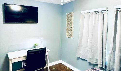 a room with a desk with a chair and a window at Relax & Unwind in 2BR 1BA Home in Quiet Neighborhood in Nederland