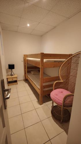 Cette chambre comprend 2 lits superposés et une chaise. dans l'établissement Appartement au calme en rdc, à Banyuls-sur-Mer