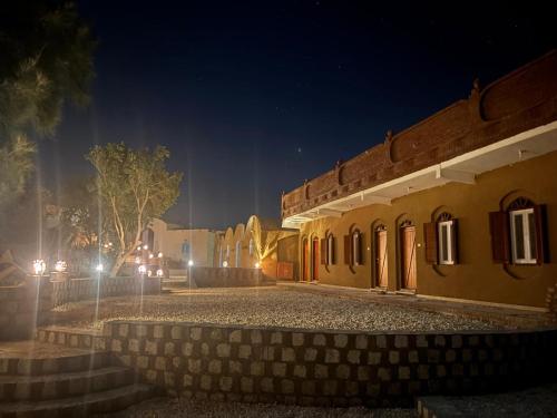a group of buildings at night with lights at Beir El Gabal Hotel (with Hot Springs) in Al Qaşr