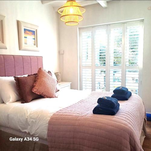a bedroom with a bed with two blue towels on it at The Homestead -Cosy Cottage for 2 in Wells next the Sea