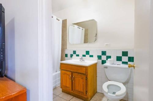 une salle de bain avec toilettes, lavabo et miroir dans l'établissement Hillside Manor Motel, à Hillside