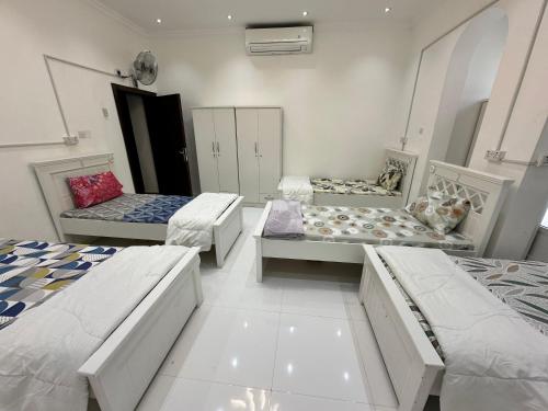 a room with three beds in a room at International Abu Dhabi Hostel in Abu Dhabi