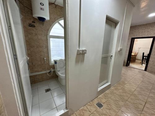 a bathroom with a toilet and a walk in shower at International Abu Dhabi Hostel in Abu Dhabi