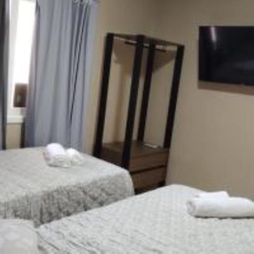 a hotel room with two beds and a mirror at Pousada do Trinta in Fernando de Noronha