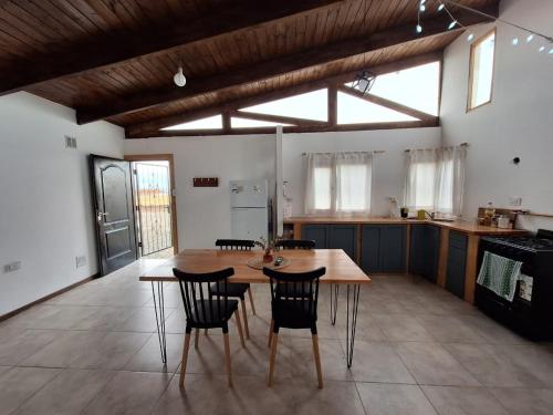 a large kitchen with a wooden table and chairs at Casa BAO in Río Gallegos