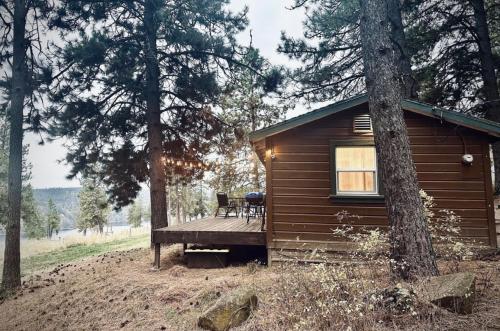 a cabin in the woods with a wooden deck at Cozy Cabin with Coeur d'Alene Lake views in Coeur d'Alene