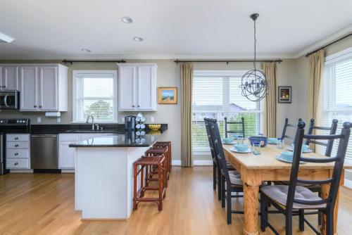 a kitchen and dining room with a table and chairs at Rolling Tide - Short Walk to the Beach in Cedar Reef Villas