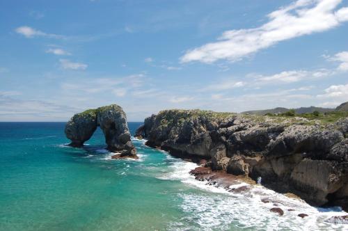 a rock formation in the ocean next to the ocean at Gestiona2R - Casa Dos Carmenes, caminando a la playa, ideal familias in Llanes