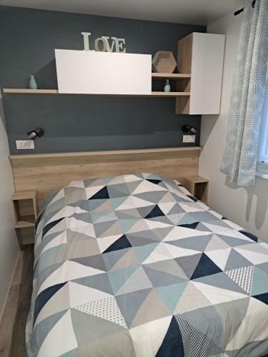 - une chambre avec un lit à la décoration géométrique dans l'établissement Le Cozy'Land - Mobilhome Camping La Réserve, à Gastes