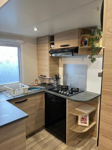 une cuisine avec une cuisinière et un évier dans l'établissement Mobil home SFI, à Canet