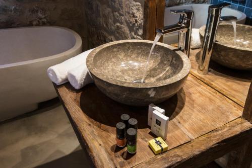 a bathroom with a bowl sink and a tub at Elafos Spa Hotel in Elliniko