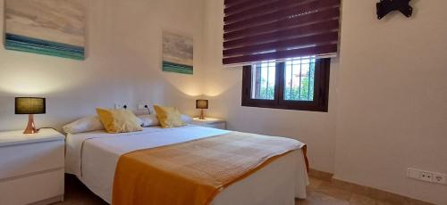 biała sypialnia z łóżkiem i oknem w obiekcie Apartamento de tres dormitorios muy espacioso con jardines y piscinas w mieście Estepona