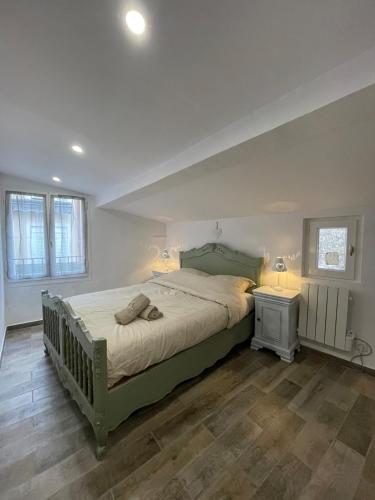- une chambre avec un grand lit vert et 2 fenêtres dans l'établissement Maison de charme, à Apt