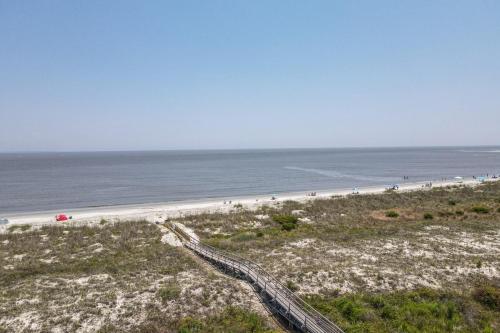 a view of a beach with people walking on it at Charleston Charm - Pool & Ocean Views in Cedar Reef Villas