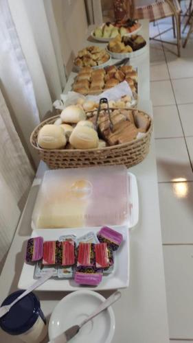 a table with several baskets of pastries and other foods at Pousada do Trinta in Fernando de Noronha