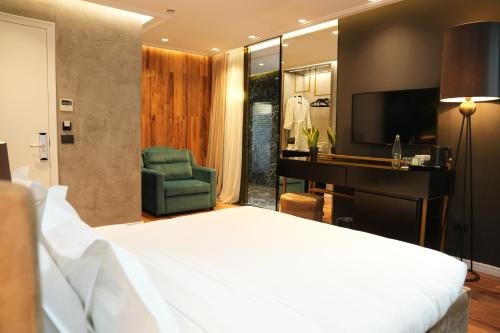 a bedroom with a bed and a desk and a television at La Suite Boutique Hotel in Tirana