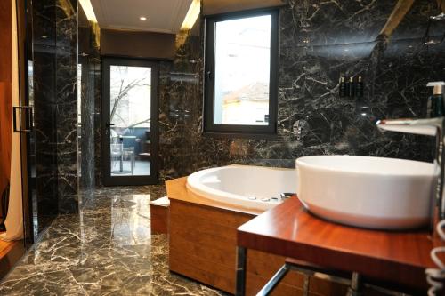 a bathroom with a tub and a sink at La Suite Boutique Hotel in Tirana